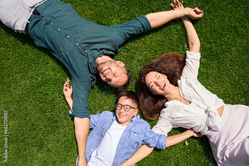 Happy family lies hugging on the front lawn