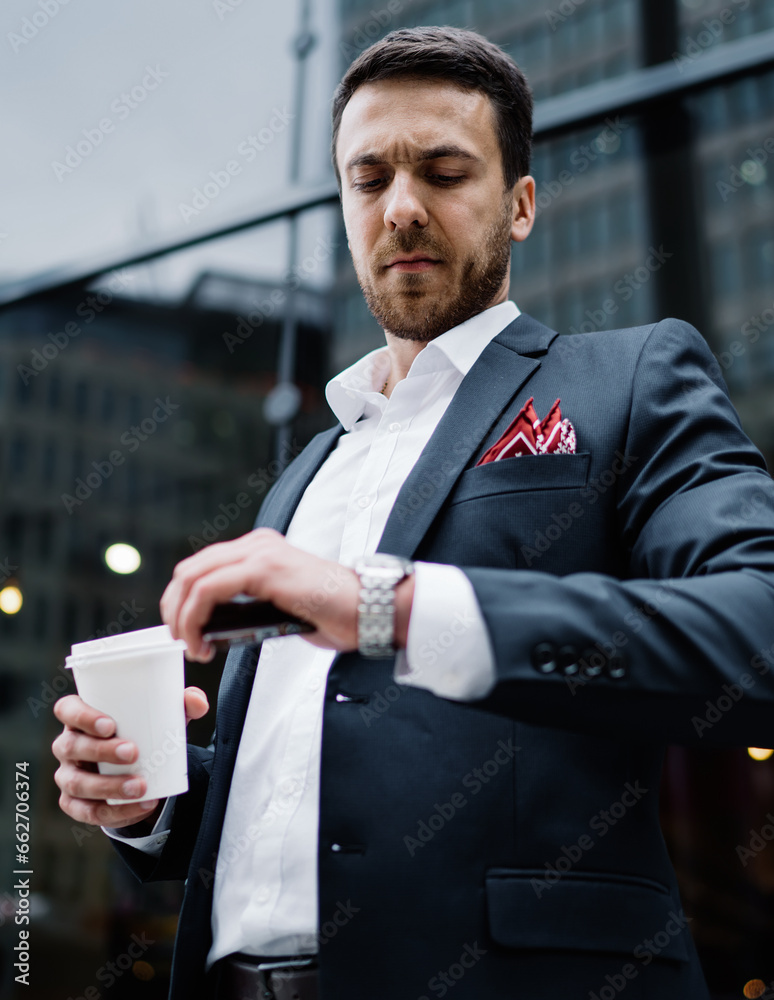 Busy male manager in formal wear checking wristwatch at city street Busy male manager in formal wear checking wristwatch at city street