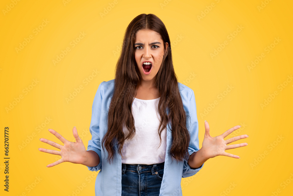 Angry teen expressing frustration, surrounded by a vibrant yellow background Angry teen expressing frustration, surrounded by a vibrant yellow background