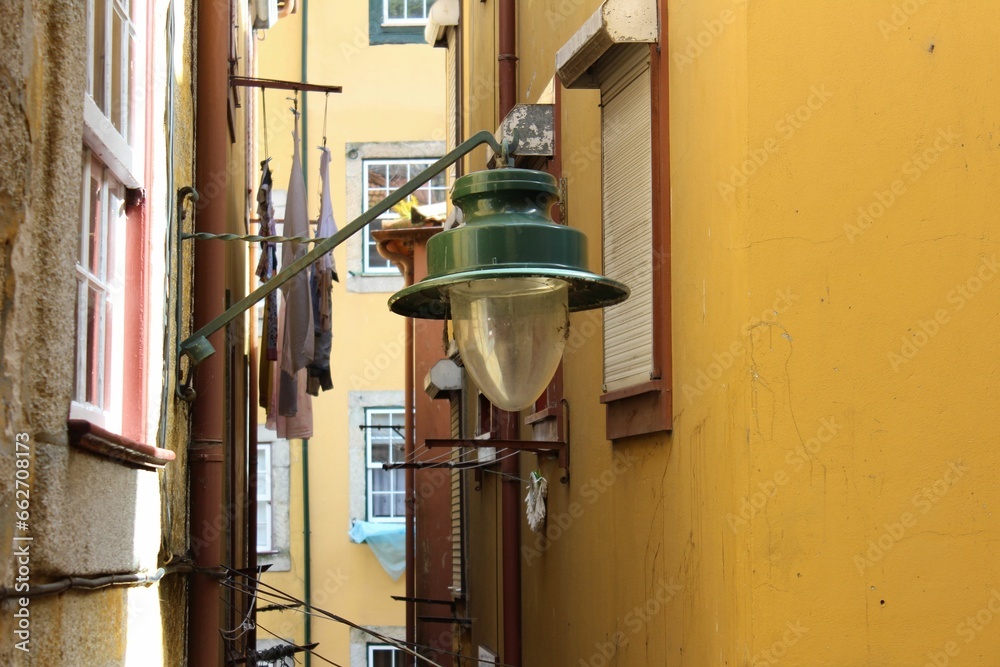 Expansive alley with a single lamp in the foreground against a yellow building