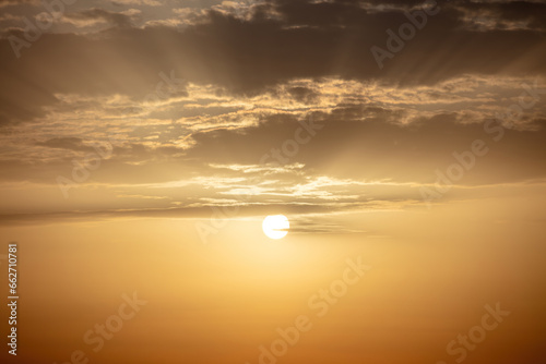 Sunset background. Sunbeam colors the sky, gold sun behind cloud. Ad template for scary movie. Space