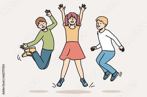 Cheerful children jumping together and enjoying life symbolize happy childhood and lack of worries in adolescence. Children boys and girls having fun enjoying vacation or weekend at school