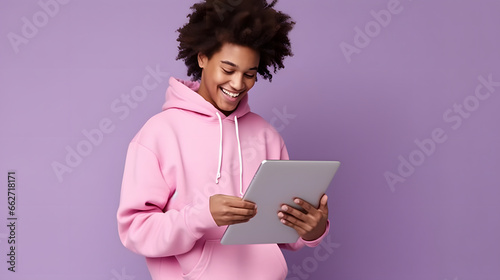 Tableau sur toile young african descendant dressed in purple checking tablet on purple background