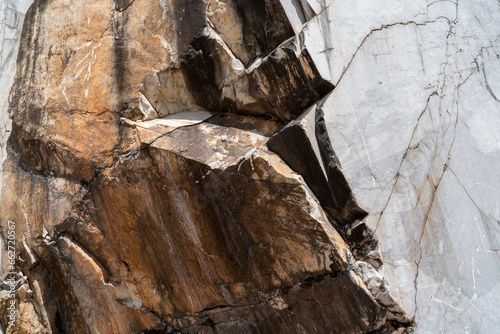 Brown white rock texture. Rough mountain surface. Close-up.  white Carrara marble in the quarry background with space for design. Crumbled. Weathered. Copy space. Natural resources from Italy, Europe