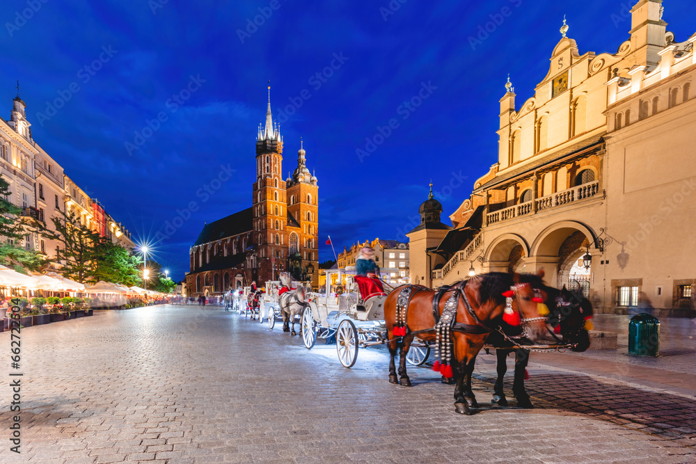 Naklejka premium Horse carriage in the market square at the evening old town in Cracow, Poland