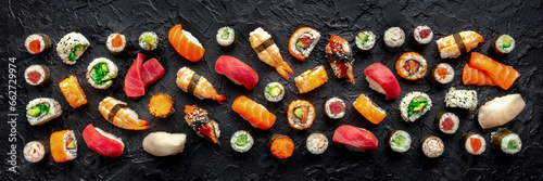 Sushi panorama. An assortment of rolls, maki, nigiri etc, overhead flat lay composition on a black background. Japanese restaurant menu