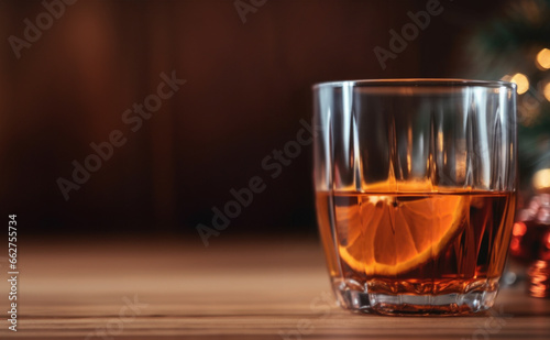 Wine, cognac or brandy in glass, bokeh lights, wooden table. Holiday image with copy space.