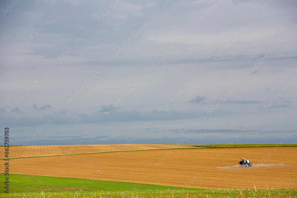 open landscape with large fields and tractor spraying in the north of france