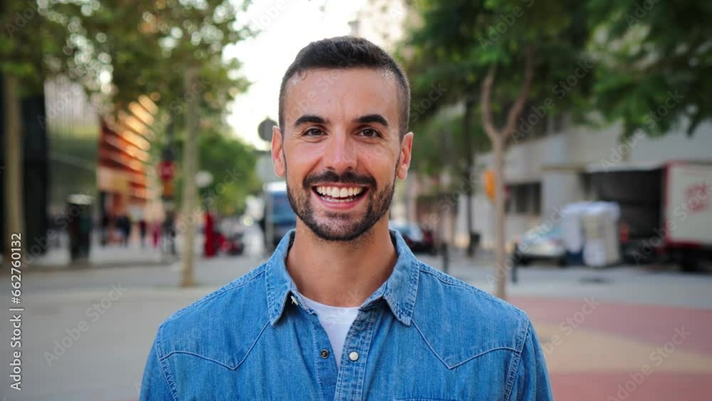 Close up portrait of handsome guy with perfect white teeth smiling and looking at camera standing outdoors. Front view of young man with friendly and positive expression. Happy adult male staring Close up portrait of handsome guy with perfect white teeth smiling and looking at camera standing outdoors. Front view of young man with friendly and positive expression. Happy adult male staring