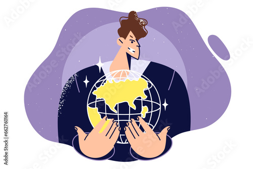 Business man holds globe and smiles slyly, dreaming creating international corporation