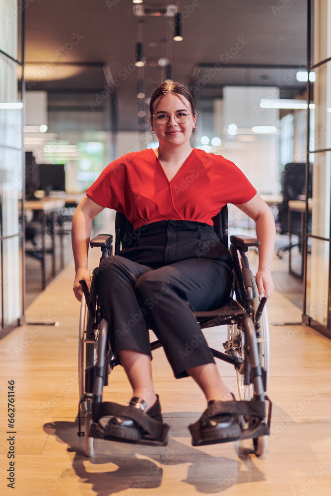 Fototapeta premium A modern young businesswoman in a wheelchair is surrounded by an inclusive workspace with glass-walled offices, embodying determination and innovation in the business world