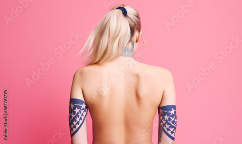 Bandana tattoo on rear bicep; woman from back with arm and neck tattoo, bleach blonde hair