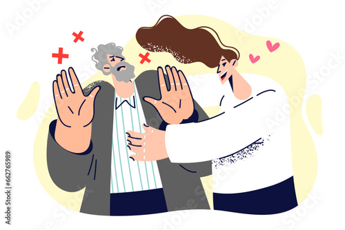 Woman tries to hug resisting man who does not want intimacy and shows stop gesture with hands