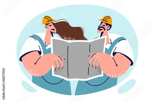 Man and woman builders are holding architectural drawing and smilingly studying plan construction
