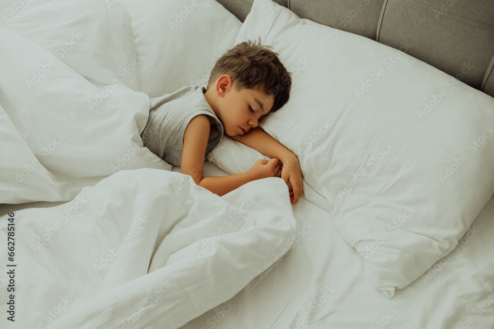 Calm little child sleeping well in comfortable bed. Boy in light cozy bedroom. Calm little child sleeping well in comfortable bed. Boy in light cozy bedroom.