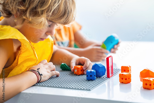 Robotics programming class. Preschool Children construct and code Robot. STEM education using constructor blocks and laptop, remote control joystick. Technology educational development for school kids