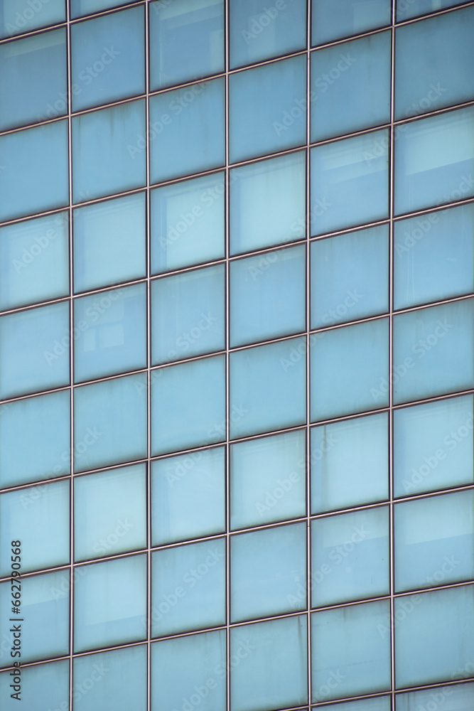 Close-up of a light blue glazed facade with square-shaped glass panels Close-up of a light blue glazed facade with square-shaped glass panels