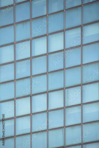 Close-up of a light blue glazed facade with square-shaped glass panels