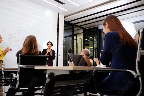 фотографія A team of business people sits in a meeting to plan an event.