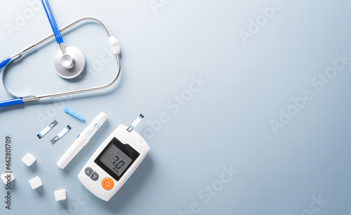 World Diabetes day concept ,14 November. Top view of blood glucose meter sets and stethoscope on pastel blue background.