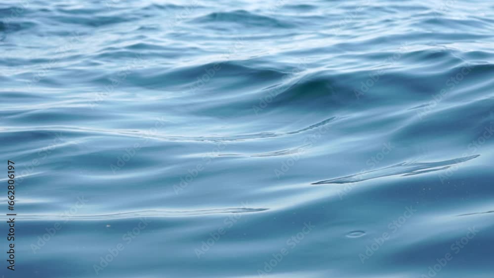 Sea water surface. Low angle view over clear azure sea water. Sun glare. Abstract nautical summer ocean nature. Holiday, vacation and travel concept. Nobody. Slow motion. Weather and climate change
