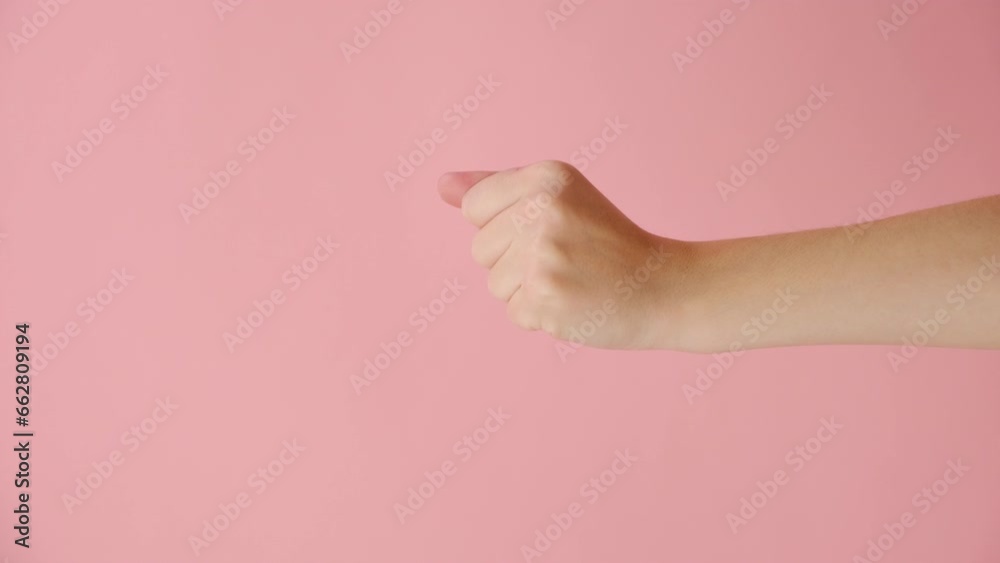 Vertical video of female hand pointing on you and come closer, isolated on pink color background with copy space for advertisement. Body language concept. With place for text or promotional content
