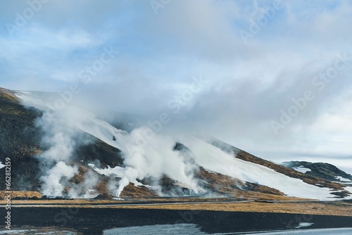 Geothermal geyser in Iceland, with a mountain in the background