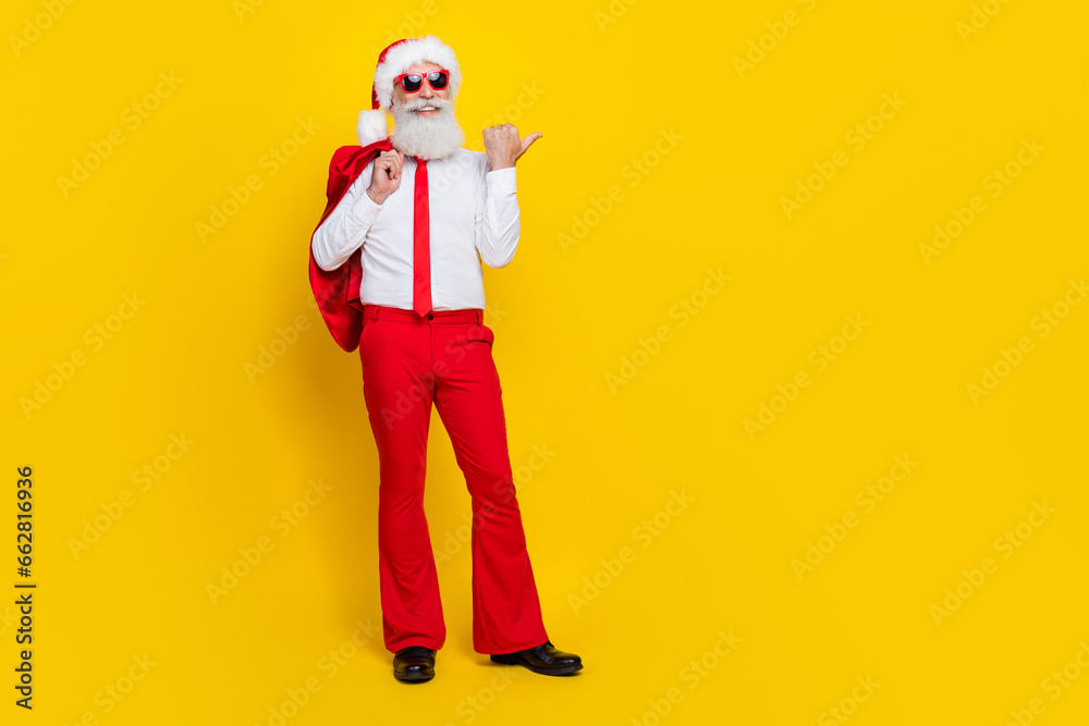 Full length portrait of classy handsome man direct thumb finger empty space offer promo isolated on yellow color background Full length portrait of classy handsome man direct thumb finger empty space offer promo isolated on yellow color background