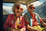A very old happy couple with sunglasses and colourful summer clothes sits in the back of a car on a tour through the mountains.