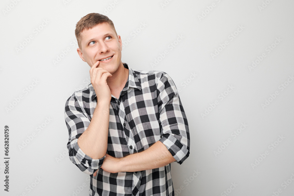 Portrait of clever man in shirt touching chin thinks doubts chooses isolated on white studio background with copy space Portrait of clever man in shirt touching chin thinks doubts chooses isolated on white studio background with copy space