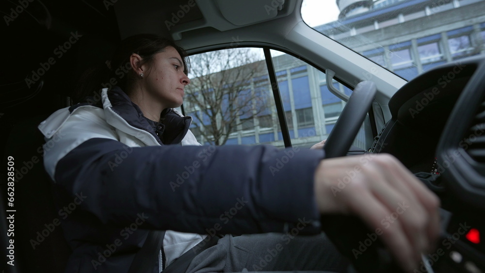 Woman driving rental truck. Interior of moving car female driver drives a stick shift car on road