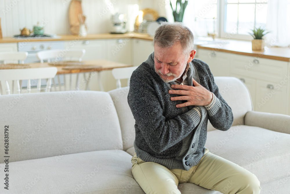 Pain on heart, heart attack. Unhappy middle aged senior man suffering from chest pain heart attack problems with health at home. Mature old senior grandfather touching chest experiencing infarction Pain on heart, heart attack. Unhappy middle aged senior man suffering from chest pain heart attack problems with health at home. Mature old senior grandfather touching chest experiencing infarction