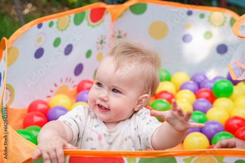 The kid baby is having fun in a dry pool with balls. Having fun in playroom Leisure Activity.