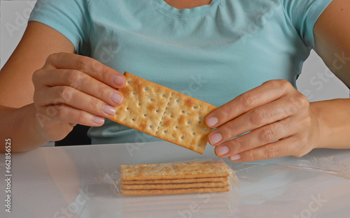 Hand hold cracker soda and pack on kitchen rable. photo
