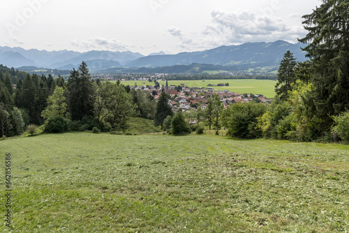 green grass on slope and Burgberger village in Iller river valley, Bavaria, Germany photo