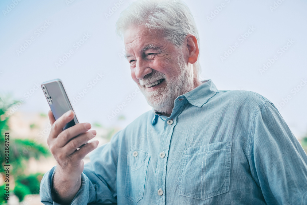 Video call concept. Handsome smiling bearded senior man talking on mobile phone using phone webcam to communicate in video chat Video call concept. Handsome smiling bearded senior man talking on mobile phone using phone webcam to communicate in video chat