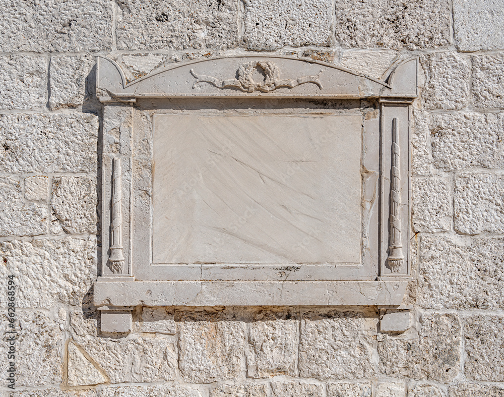 Stone tablet on the wall of an old building.