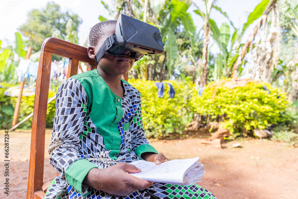 Fototapeta premium An African child does homework using an augmented reality viewer, technology in education in Africa