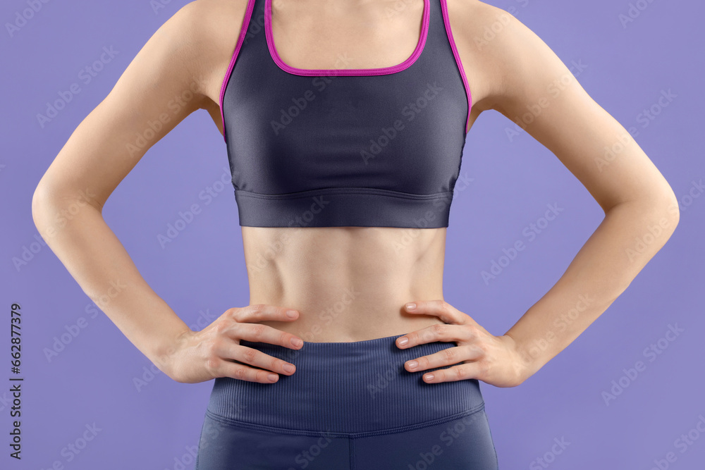 Woman wearing sportswear on violet background, closeup Woman wearing sportswear on violet background, closeup