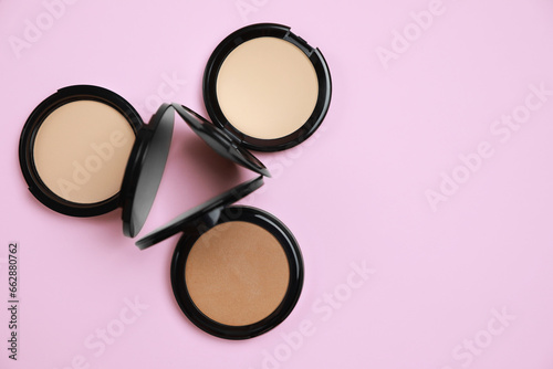 Different face powders on pink background, flat lay. Space for text