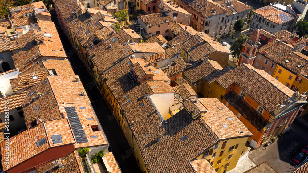 Aerial view of the sloping roofs of the houses in the historic center of Reggio Emilia, Italy. The orange color of traditional roofs predominates.