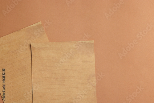 Sheets of old parchment paper on brown background, flat lay. Space for text