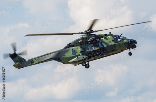 Fototapeta Naklejka Na Ścianę i Meble -  Untitled military helicopter at air base. Air force and army flight transportation. Aviation and rotorcraft. Transport and airlift. Military industry. Fly and flying.