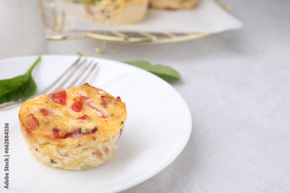 Freshly baked bacon and egg muffin with cheese on light gray table, space for text Freshly baked bacon and egg muffin with cheese on light gray table, space for text