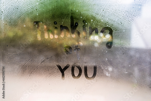 Thinking of you - inscription on a foggy window, glass.