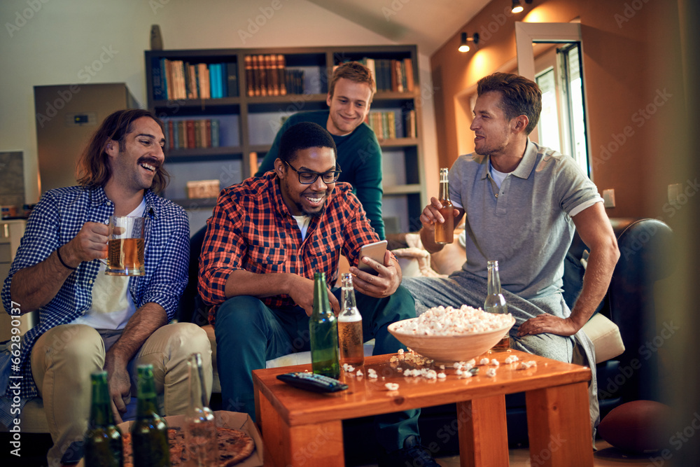 Young and diverse group of friends using a smartphone while watching sports in the living room