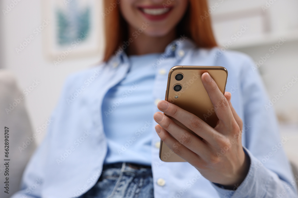 Woman sending message via smartphone indoors, closeup Woman sending message via smartphone indoors, closeup