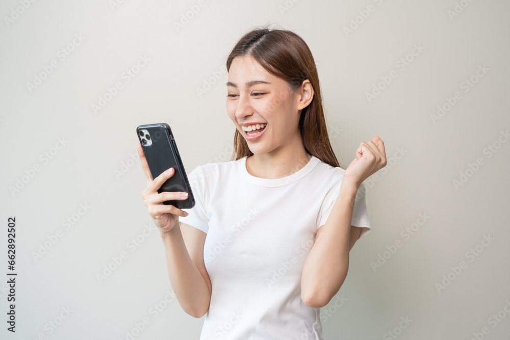Happy Asian woman holding a smartphone and winning the prize. Happy Asian woman holding a smartphone and winning the prize.