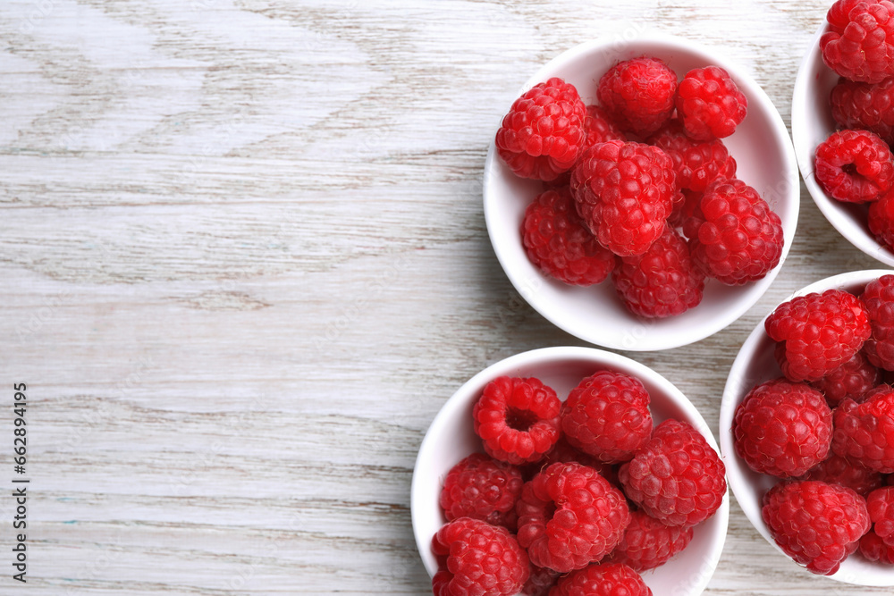 Tasty ripe raspberries on white wooden table, flat lay. Space for text