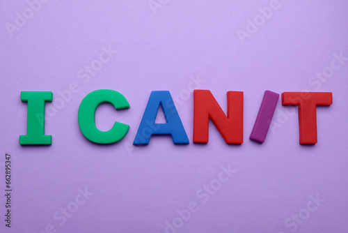 Motivation concept. Changing phrase from I Can't into I Can by adding slash symbol on violet background, flat lay